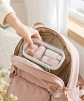 Person placing 7 Inch Clear Hard Shell Zipper Case Set With Double Zippers in a pink backpack.