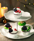 Cupcakes decorated with mini black top hats from Awesome Christmas Craft Button Kit with 700 Pieces.