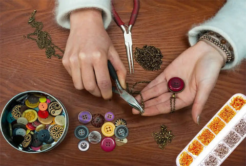 Person using pliers from Jump Ring Jewelry Making Kit With 1200 Silver And Gold Rings Pliers Tweezers Opener And Brass Ring Tools.