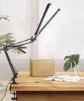 Two In One LED Desk Lamp With Dual Heads And Clamp Or Base Mount on wooden desk in home office