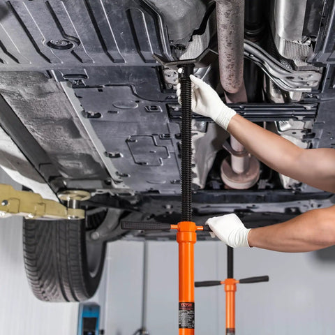 Underhoist Support Stand Three Quarter Ton Capacity With Two Wheels Adjustable Height From Fifty One To Eighty Inches Bearing Mounted Spin Handle And Foot Pedal Built Tough Tubular Steel Vehicle Lift Stand For Auto Repair in use under vehicle