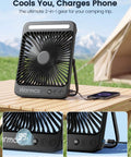 20,000mAh Portable Camping Fan With LED Lantern on wooden table showing digital display and USB-C charging with phone, outdoor setting