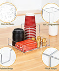 Clear Acrylic Coffee Cup Holder For Countertop With Three Compartments For Cups Lids Straws Pods Sugar Packets And Tea Bags A Handy Coffee Bar Organizer For Kitchen Counters showing cups and sugar packets