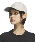 Woman wearing Superlite Hat For Women Lightweight Moisture Wicking Cap For Gym Ready Workouts And Training with UPF 50 Sun Protection in beige.