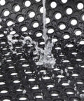 Heavy Duty Commercial Rubber Floor Mat Featuring Hexagonal Drainage Cutouts For Garage And Shop Kick Ass Non Slip Oil Grease Resistant Tough As Nails Level with water splashing on surface.