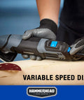 Hammerhead 2.2-Amp oscillating multi-tool with blue dial; side view on wood with blades and sanding pad