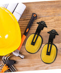 Job Site Tough Safety Hard Hat Ear Muffs With Integrated Noise Blocking Cups For Industrial Hearing Protection And Heavy Duty Construction Environments on a workbench with tools.