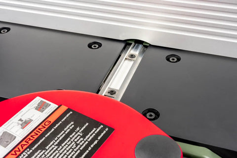 Close-up of the Six Inch Spiral Cutterhead Benchtop Jointer Loaded With Teflon Coated Aluminum Tables and safety label.
