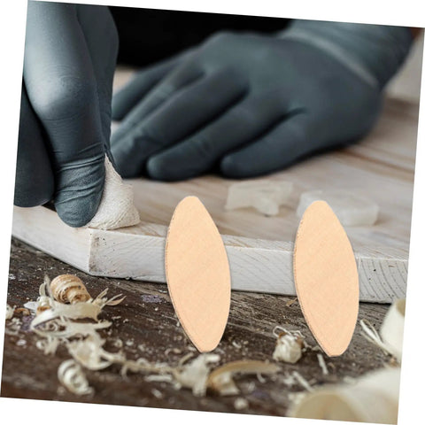 Gloved hand using 100 Pcs Wood Joiner Biscuits Set For Woodworking Projects with shavings, showcasing pro grade biscuit joiner tool.