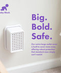 Extra Large Outlet Cover Box for Baby Proofing bulky plugs and wide adapters, white, installed in a room with text 'Big. Bold. Safe.'