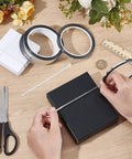 Person applying Premium Metallic Mirror Trim Tape Heavy Duty Pet Self Adhesive Roll to a black gift box alongside scissors.