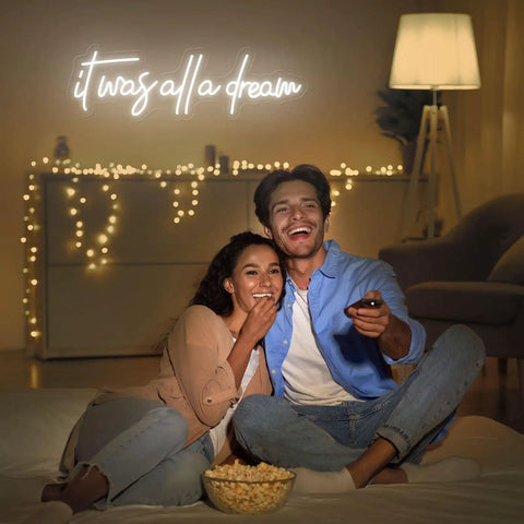 Couple in front of 'It Was All A Dream Neon Sign LED Wall Decor 27 By 8.5 Inch Timed Dimmable Neon Lights' in cozy setting.