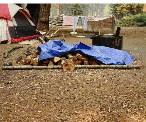 Tough Waterproof Heavy Duty Poly Tarp 12x16 Foot With Grommets Every 36 Inches covering firewood at a campsite