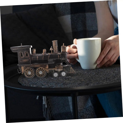 Vintage Steam Locomotive Model Sculpture for Desk Decor and Living Room on a table beside a person with a mug