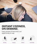 Woman napping on grey eggplant inflatable pillow with ergonomic hug design for naps and lounging, compact lightweight travel buddy.