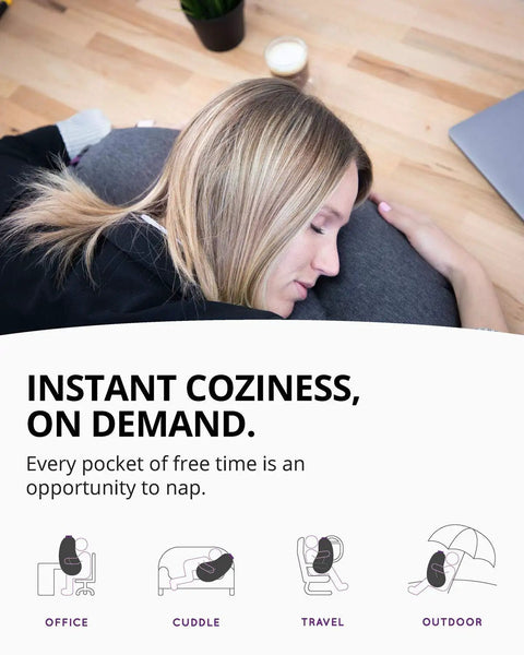 Woman napping on grey eggplant inflatable pillow with ergonomic hug design for naps and lounging, compact lightweight travel buddy.