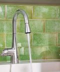 High Arc Pulldown Bar Faucet With One Handle Chrome Finish, Reflex Technology, water flowing into sink, green tile backdrop