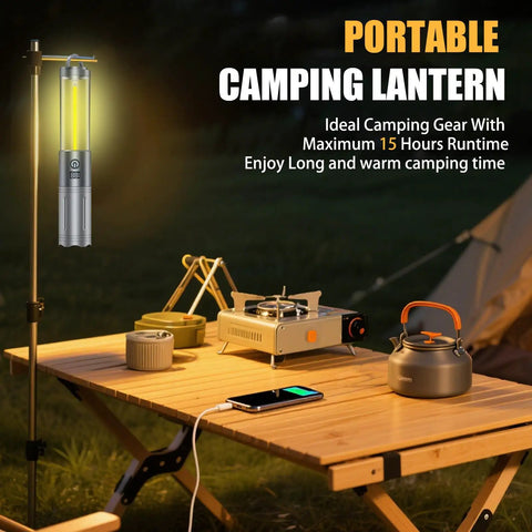 Outdoor setup with a 2 In 1 Rechargeable Camping Lantern And Flashlight with 6 Mode LED, USB output, on a table beside a tent.
