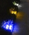 Ice Cube Solar Glass Brick Path Lights 4 Pack For Garden And Yard, glowing in blue and yellow in a nighttime garden setting.