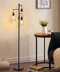 Three Light Industrial Floor Lamp With Glass Shades For Living Room Dope Vibe next to table with flowers