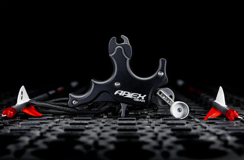 Side view of Surge 3 Finger Archery Release Aid With Grooved Finger Beds For Secure Grip, CNC Machined Aluminum on a textured surface.