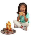 Child playing with Campfire S'mores Pretend Play Set With 23-Piece Toy Food Kit including flames and marshmallows.