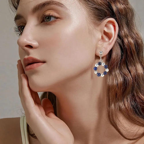 Model wearing 150 Pcs Ball Post Earring Kit With 75 Pairs Of 304 Stainless Steel Findings Including Loops And Ear Nuts 0.8mm Pin For DIY Earring Making No Tarnish Hypoallergenic Easy To Use.