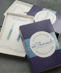 Sterling silver jewelry in packaging box featuring earrings and enCharmed logo