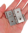 Hand holding four piece double pivot door hinges with spring loaded iron for screens and furniture heavy duty silver finish