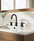 Oil Rubbed Bronze 8 Inch Widespread Bathroom Faucet With Two Handles For Three Hole Mount Includes Valve And Metal Pop Up Drain Built To Last For 6 To 12 Inch Widespread Setups WF015-1-ORB installed on a white sink with wooden vanity in bathroom