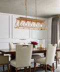 Five Light Gold Modern Farmhouse Chandelier For Kitchen Island hanging over a wooden dining table with white chairs