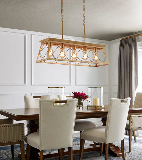 Five Light Gold Modern Farmhouse Chandelier For Kitchen Island hanging over a wooden dining table with white chairs