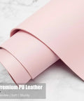 Close-up of rolled Premium PU Leather in pink, illustrating flexibility, softness, and sturdiness.