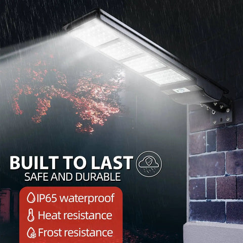 Beefed Up 300W Solar Street Light mounted on brick wall, showing IP65 waterproof and durability in rain with 8000LM flood lights.