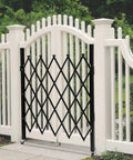 Badass Expandable Folding Security Gate 51 By 36 Inch Black Rugged Steel Diamond Grid Door with outdoor white fence background.