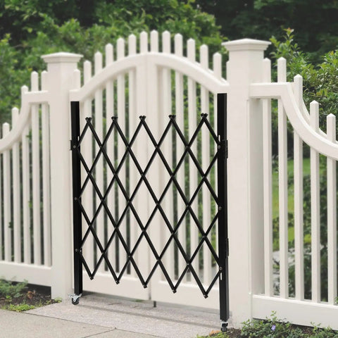 Badass Expandable Folding Security Gate 51 By 36 Inch Black Rugged Steel Diamond Grid Door with outdoor white fence background.