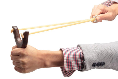 Solid Wood Slingshot With Classic Construction For Adults being held ready to launch, deep brown finish, durable rubber bands