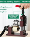 Adjustable Ring And Bracelet Bender Machine With Stainless Steel Rolling Mill For Crafting Spoon Rings And Custom Jewelry Gear shown in use, manual bending tool with red handle.