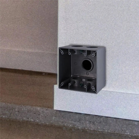 Two Gang Weatherproof Deep Electrical Box With Five Three Quarter Inch Threaded Outlets For Outdoor Wiring Die Cast Aluminum Construction Weather Resistant Box For Outlets Switches And GFCI installed on a wall.