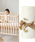 Child in crib next to rolled Bed Rail Teething Protector for sides and corners, breathable cotton gauze cover with bow.