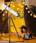 Child stargazing with 80mm Aperture 900mm Focal Length Refractor Telescope in tent, glowing lights, globe, books nearby