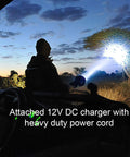 TacticPro 2000 Lumen HID Spotlight Floodlight for auto use with attached 12V DC charger illuminating a tree at dusk