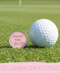 Cute Pink Golf Ball Marker Hat Clip For Women Gals Golf Accessory on grass next to a golf ball.