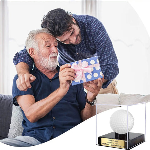 Two men smiling with a gift, Custom Golf Ball Display Case With Clear Acrylic Holder Laser Engraved Plaque in gold finish nearby