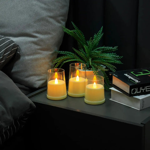 Ivory Flameless Taper Candles with Remote and Timer, Battery Operated LED Candles on a black table beside a sofa.