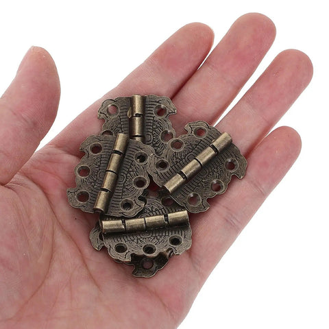 A hand holding a set of 20 Piece Mini Butterfly Hinges Set For Jewelry Boxes And Cabinets, Vintage Zinc Alloy 90 Degree Folding Hinges