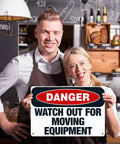 Heads Up Watch Out For Moving Equipment Aluminum Sign 8x12 Inch held by smiling people in shop setting