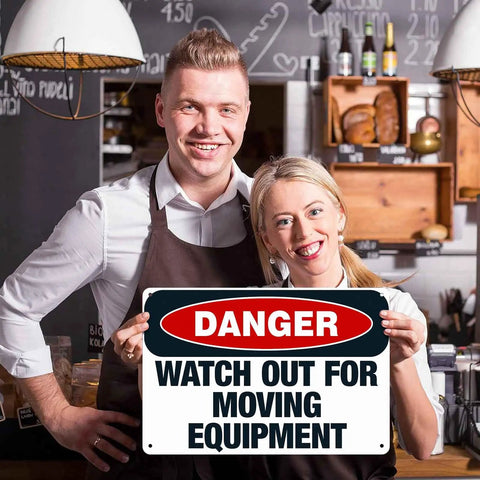 Heads Up Watch Out For Moving Equipment Aluminum Sign 8x12 Inch held by smiling people in shop setting
