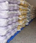 Stacks of wrapped items on interlocking plastic pallets for basement storage and garage organization, ventilated tray design.