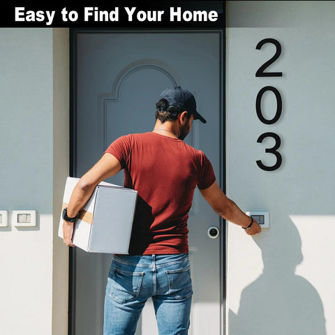 Man with package next to 8 Inch Floating Black House Numbers For Outside, Modern Address Markers For Outdoor Walls on wall